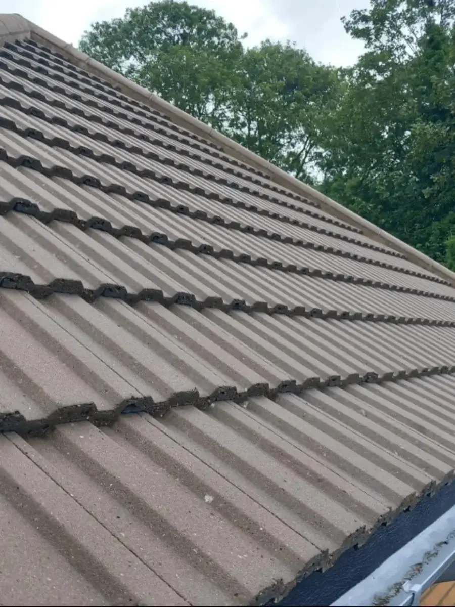 Close-up of a modern black uPVC ogee profile guttering and downpipe system installed on a light brick home by Norfolk Exterior Solutions